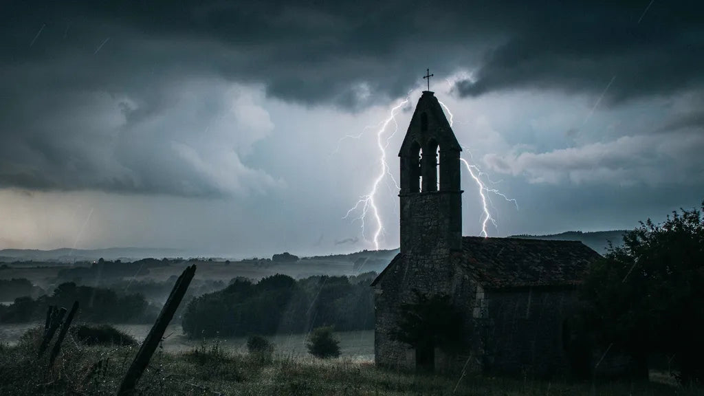 Kirchturm-Silhouette vor gewaltigem Blitzgewitter